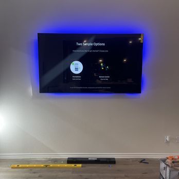 A flat screen tv is hanging on a wall in a living room.
