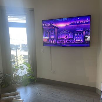 A flat screen tv is hanging on the wall in a living room.