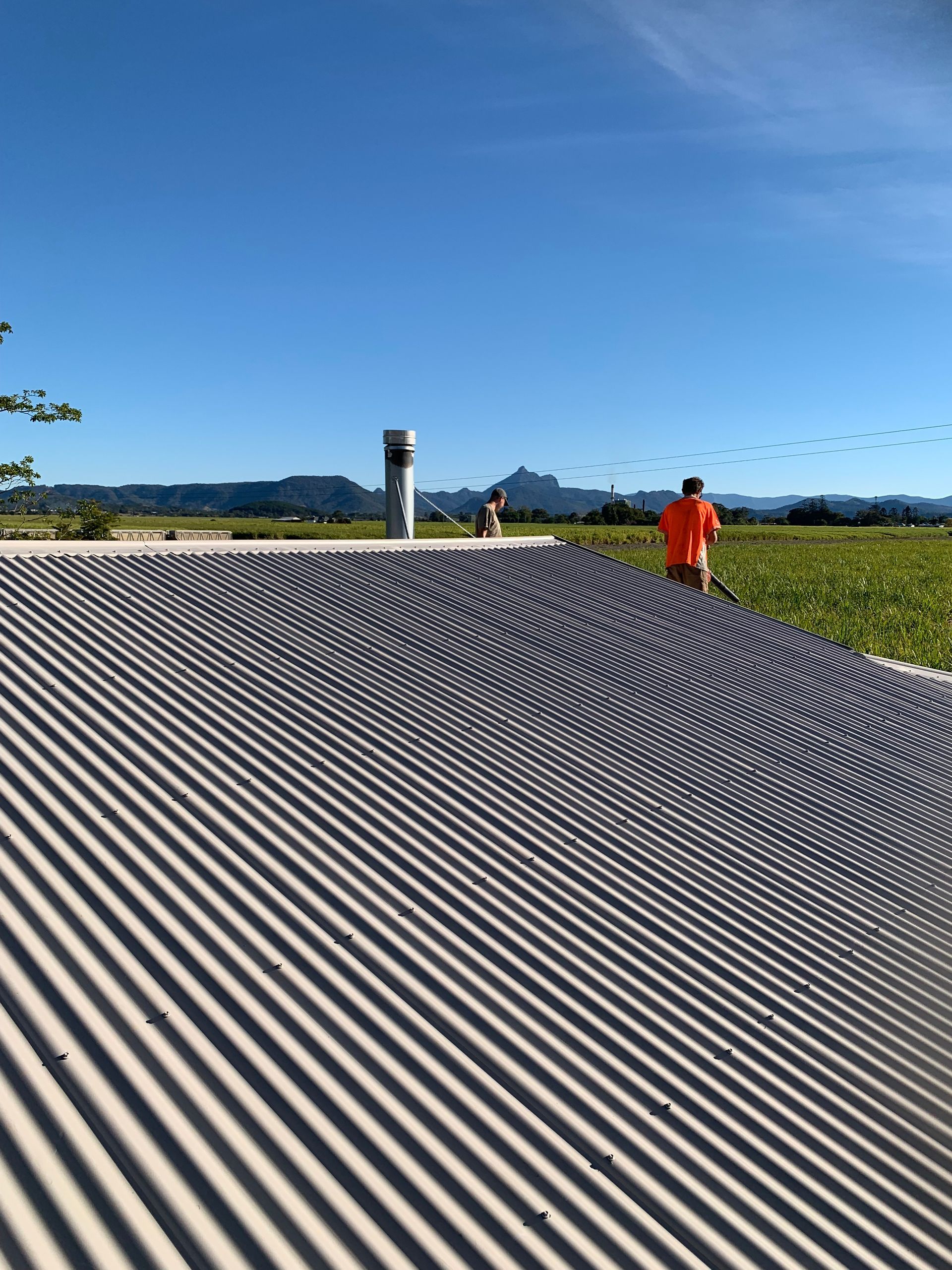 The top of a roof looking out to a field and sky— Blue Sky Roofing NSW In Mullumbimby, NSW