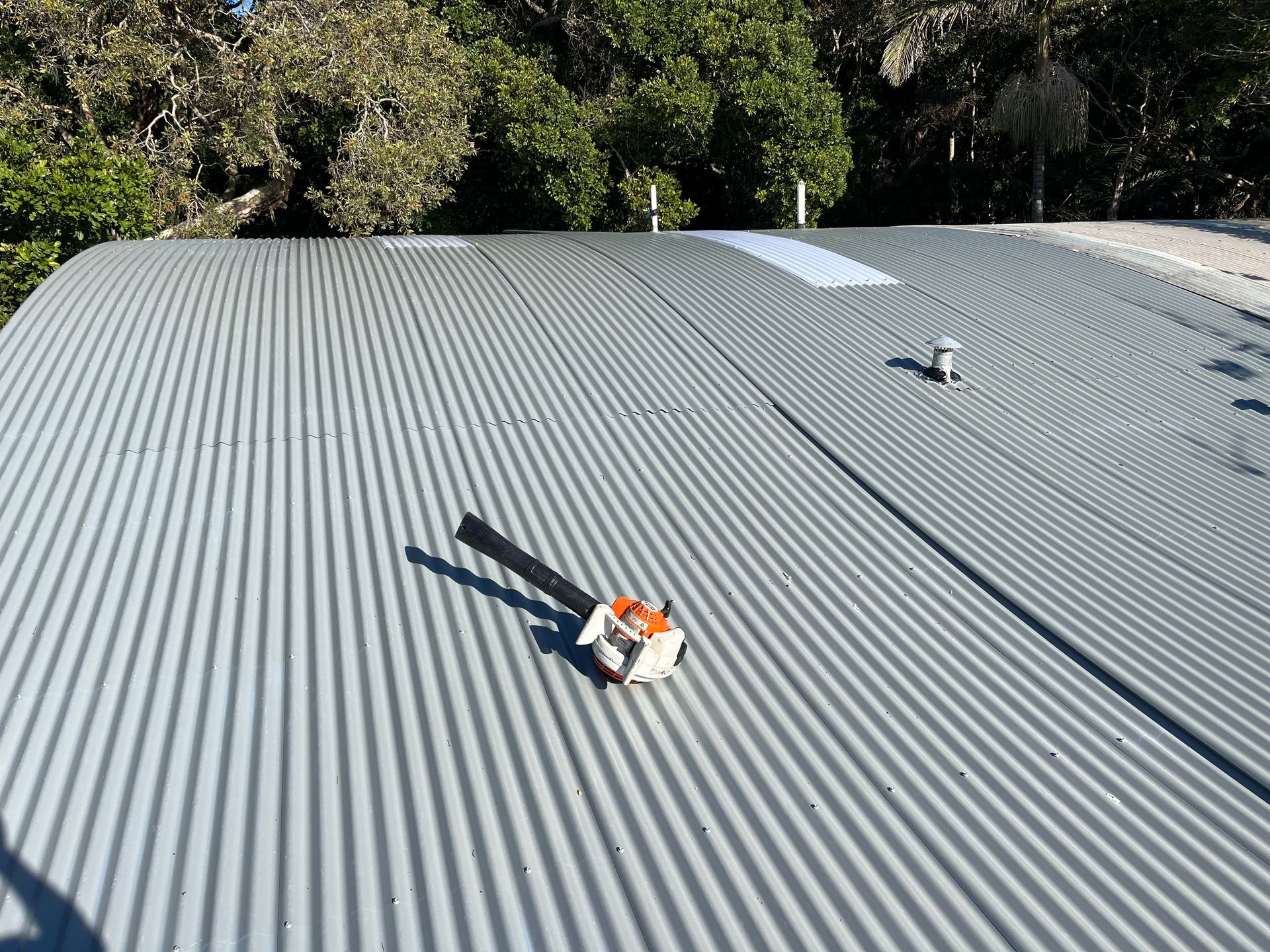 Metal Roof with tool laid down on top while getting repaired — Blue Sky Roofing NSW In Murwillumbah, NSW