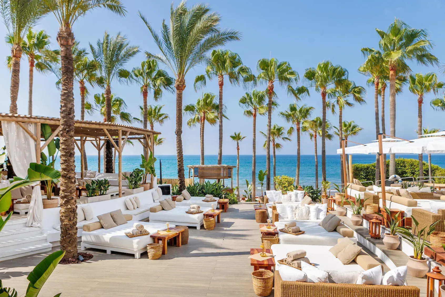 There are a lot of chairs and tables on the beach.