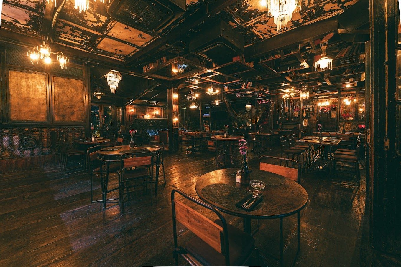 A restaurant with tables and chairs in a dark room.