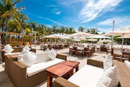 There are a lot of chairs and tables on the beach.