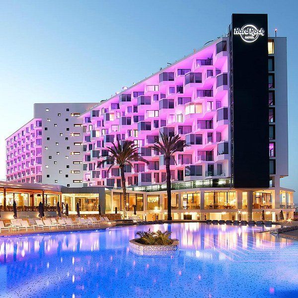 A hard rock hotel with a swimming pool in front of it