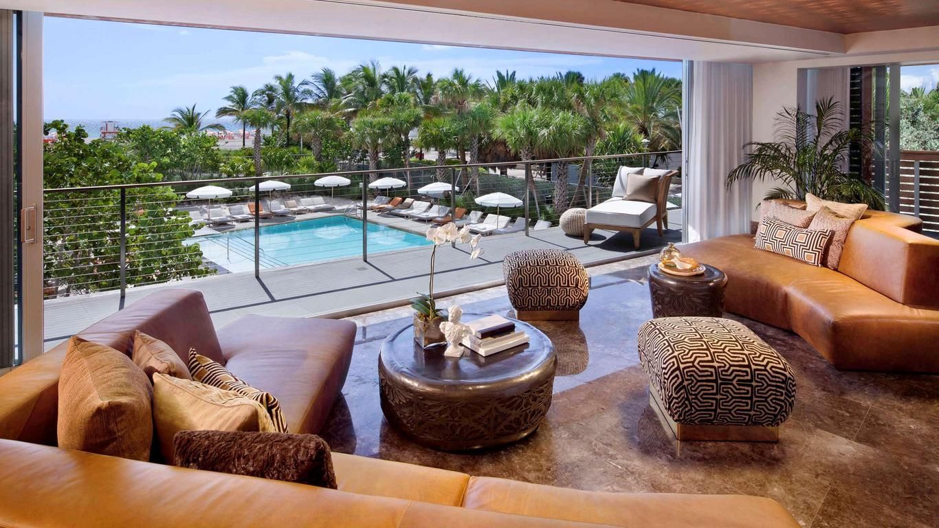 A living room with a view of a pool and trees