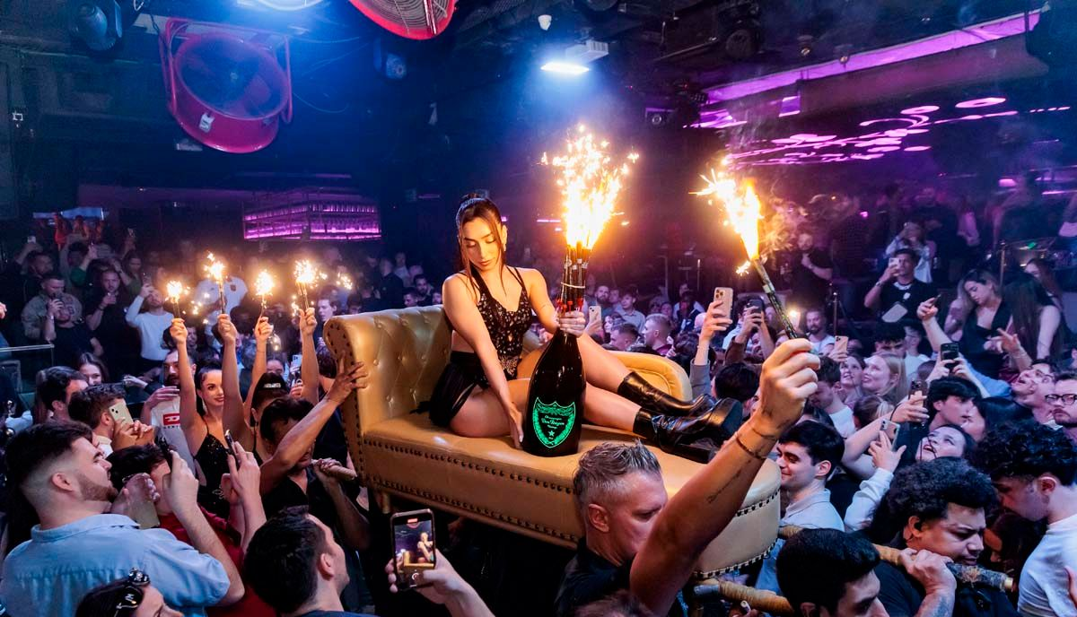 A restaurant with tables and chairs in a dark room.