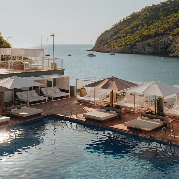 A large swimming pool surrounded by umbrellas and beds