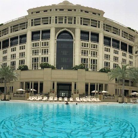 A large building with a swimming pool in front of it.