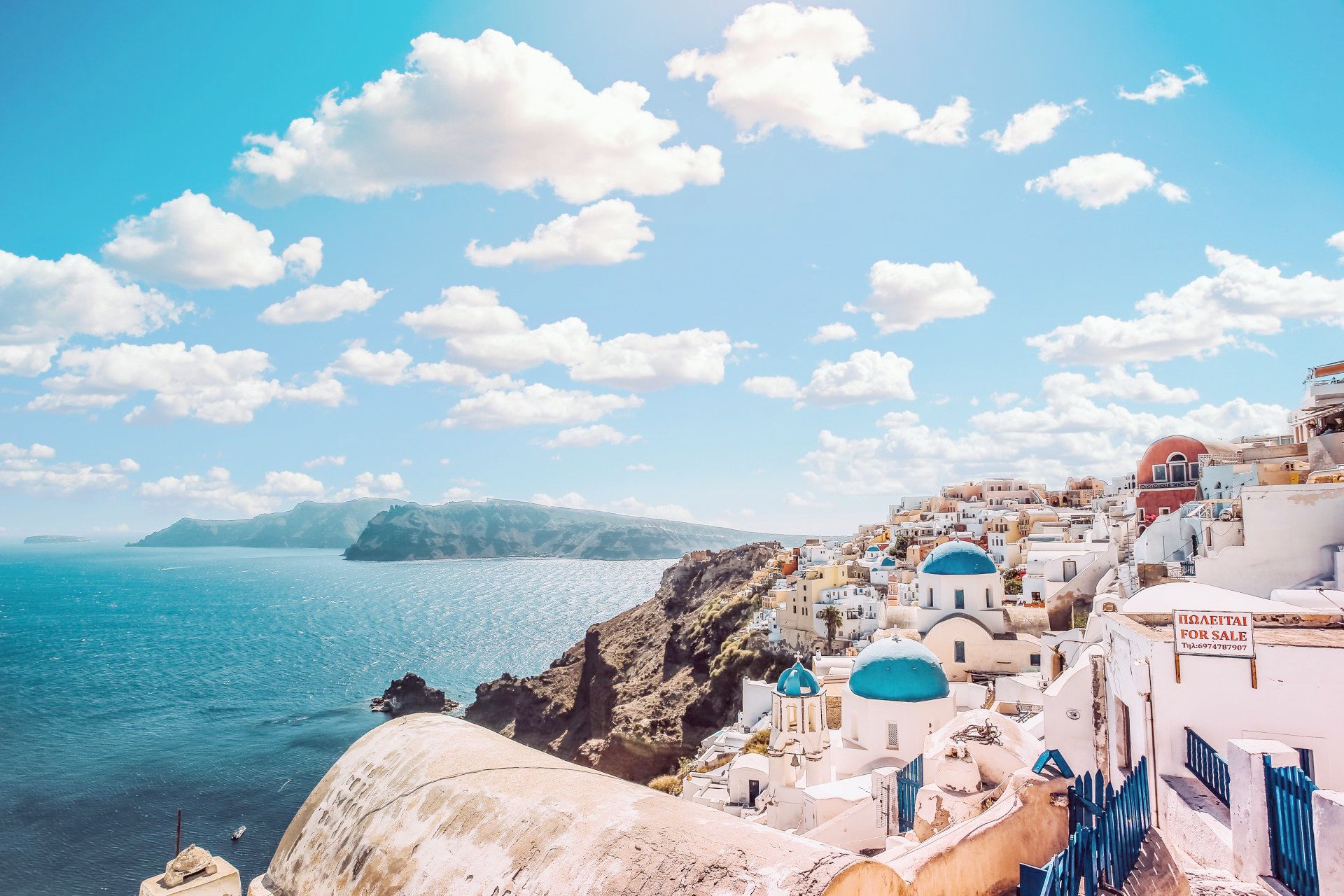 An aerial view of a small town on a cliff overlooking the ocean.