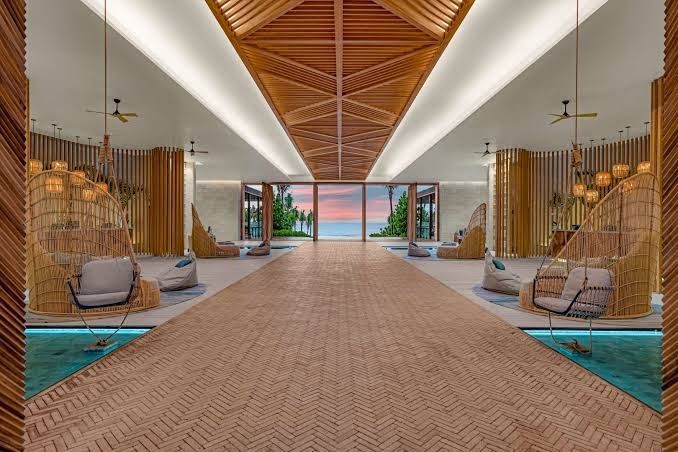 An artist 's impression of a hotel lobby with a view of the ocean.