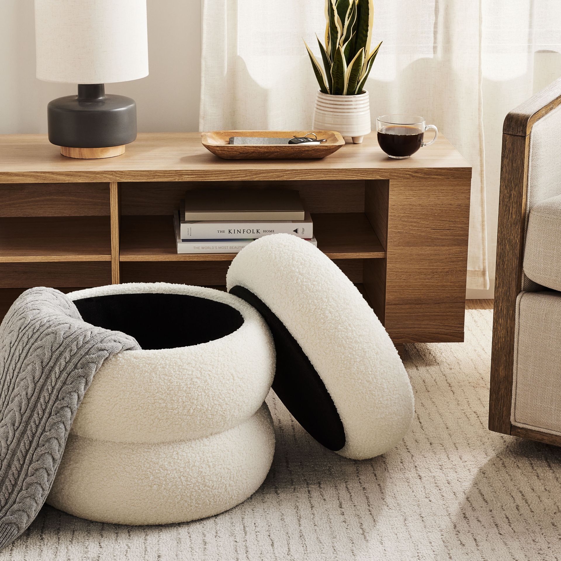 Two white ottomans are stacked on top of each other in a living room