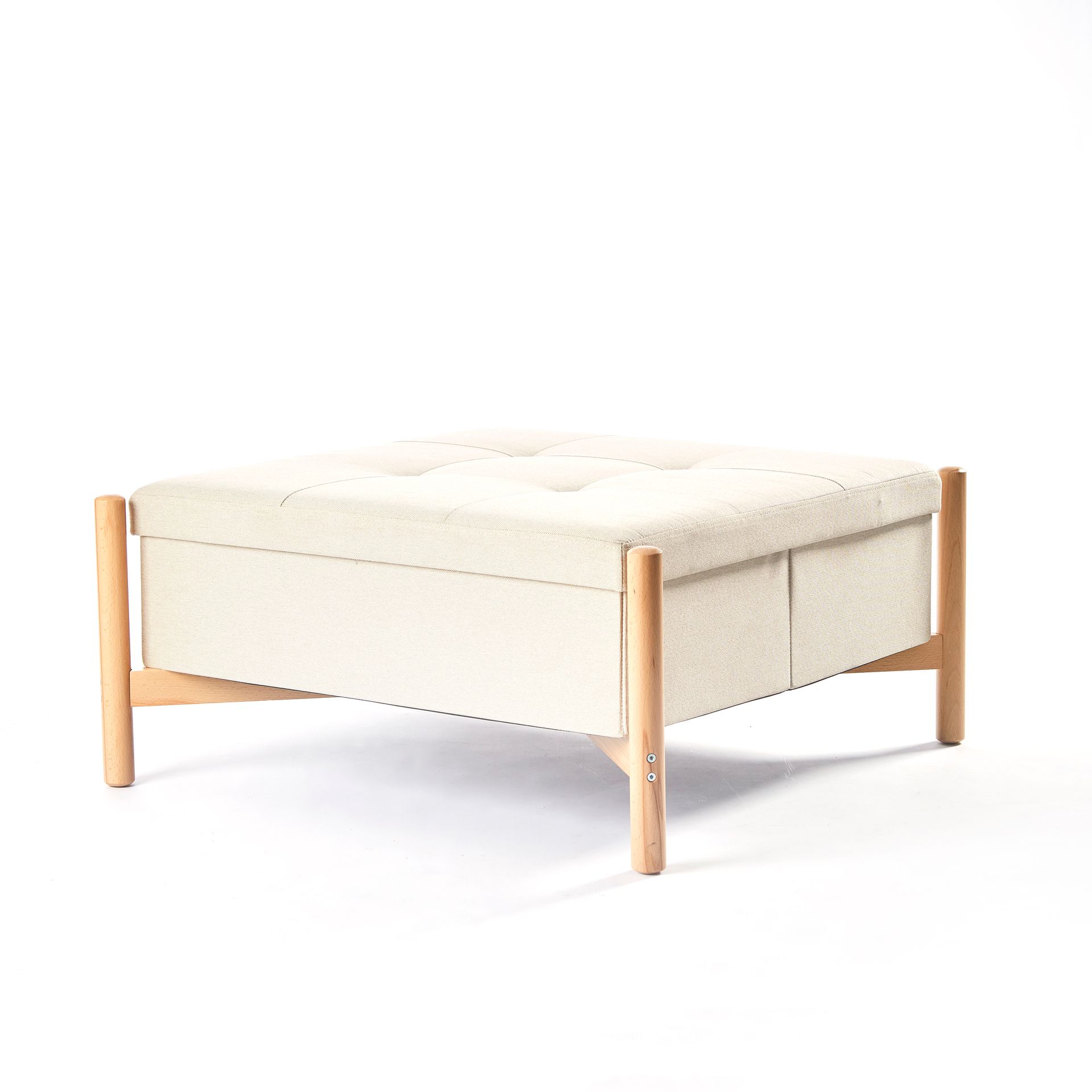 A white ottoman with wooden legs on a white background