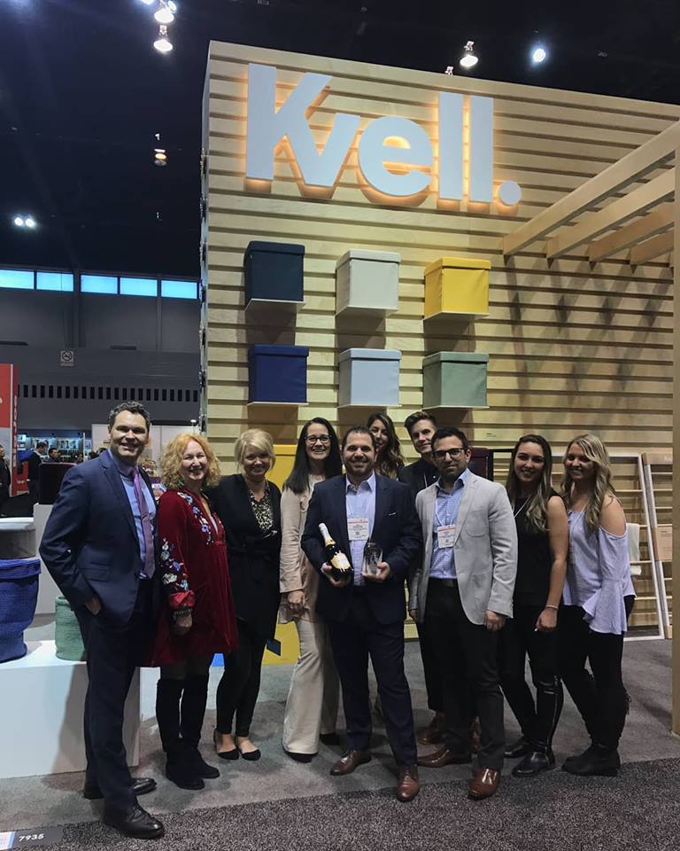 A group of people standing in front of a building that says Kvell