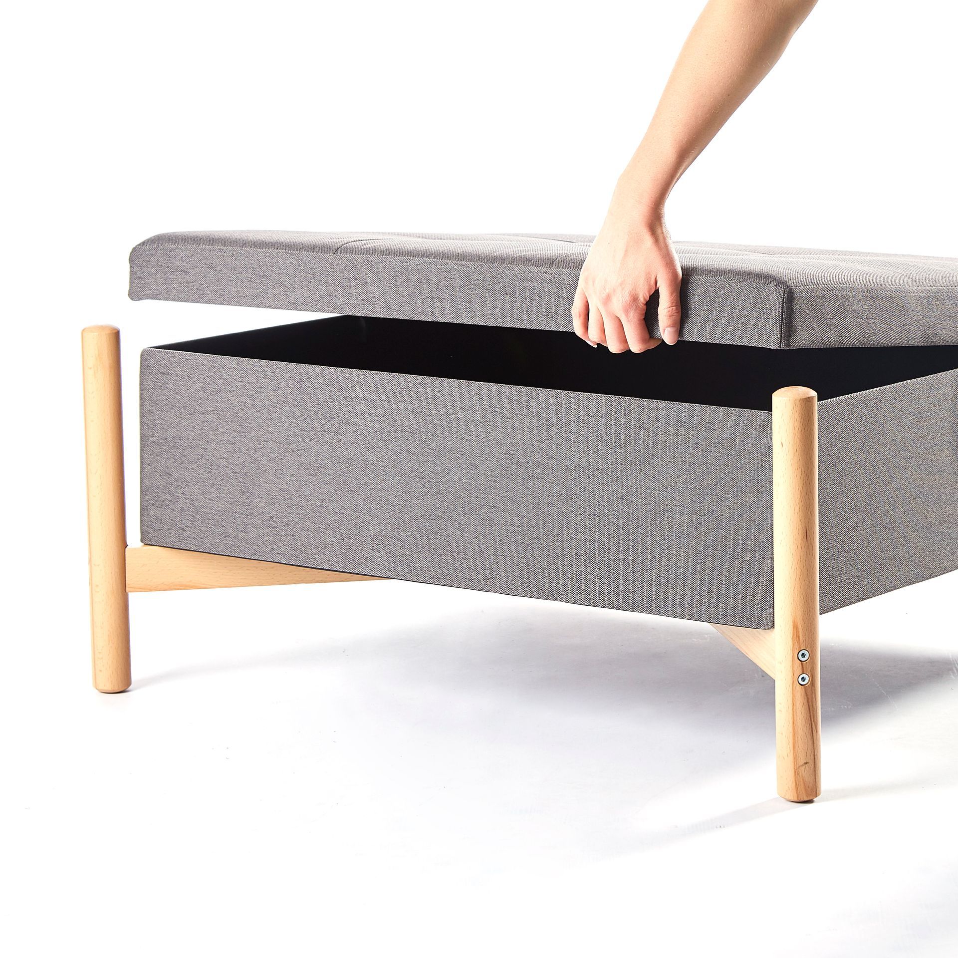 A person is opening the lid of an ottoman