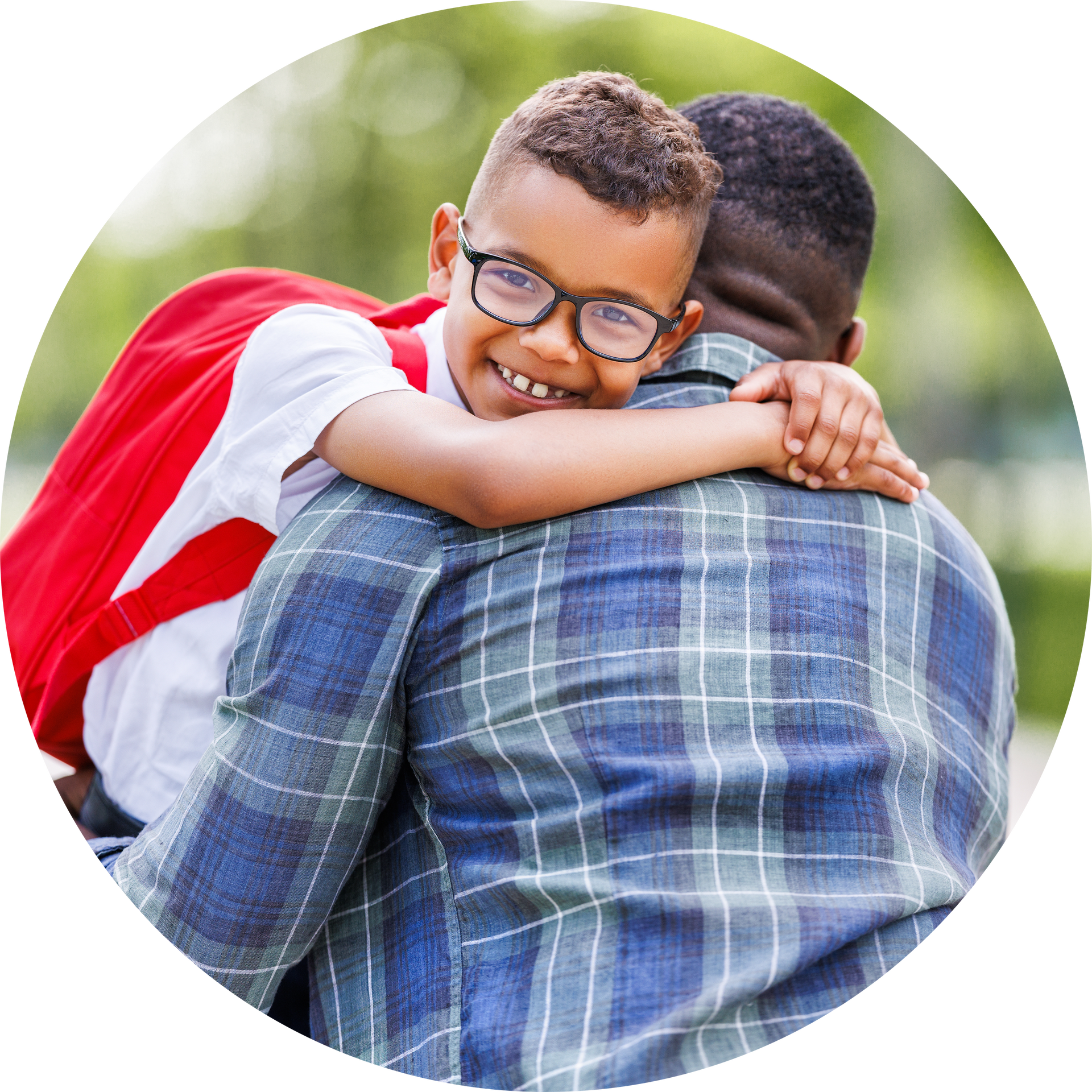 A young boy with glasses is hugging his father.