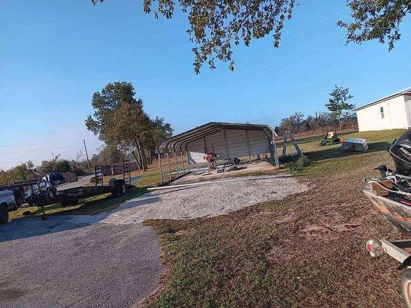 A boat is parked in front of a building on a dirt road.