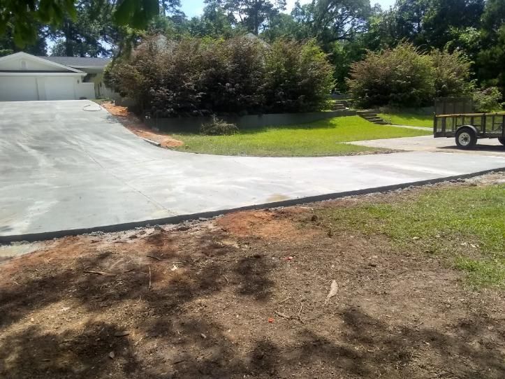 A concrete driveway is being built in front of a house.