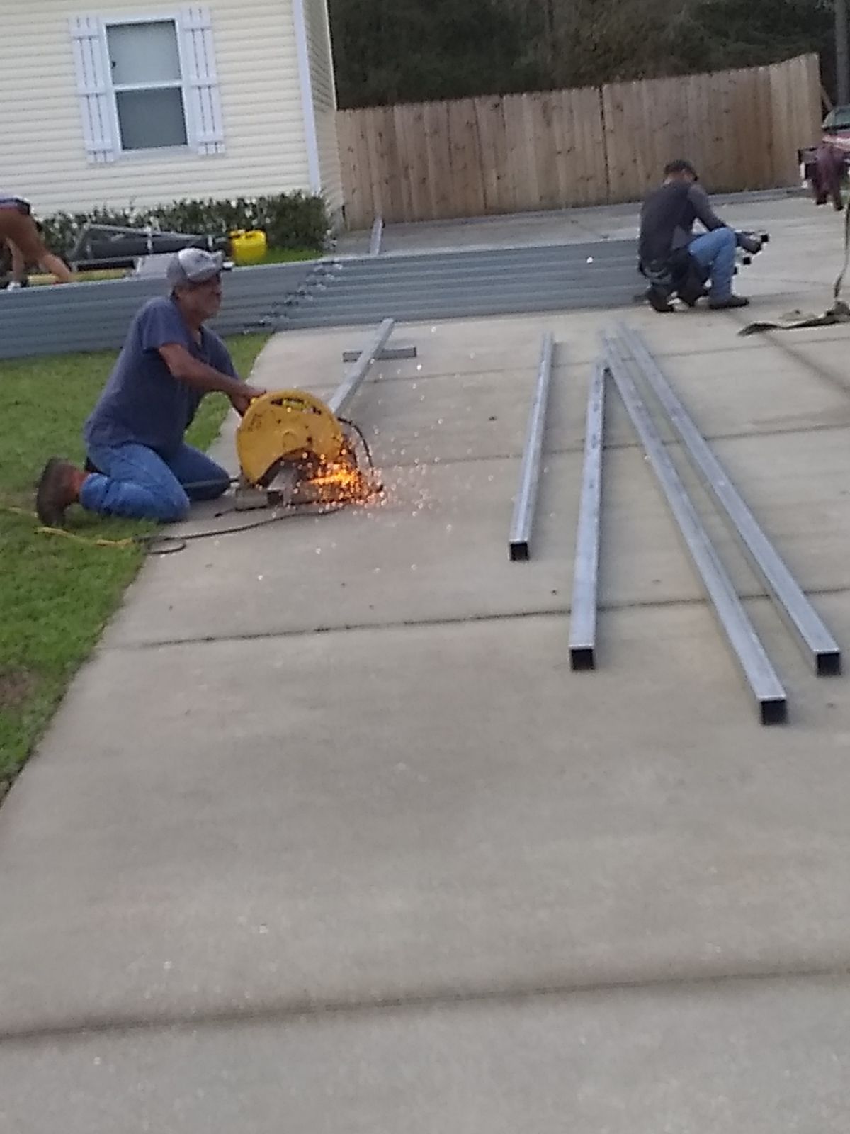 A man is cutting a piece of metal with a circular saw