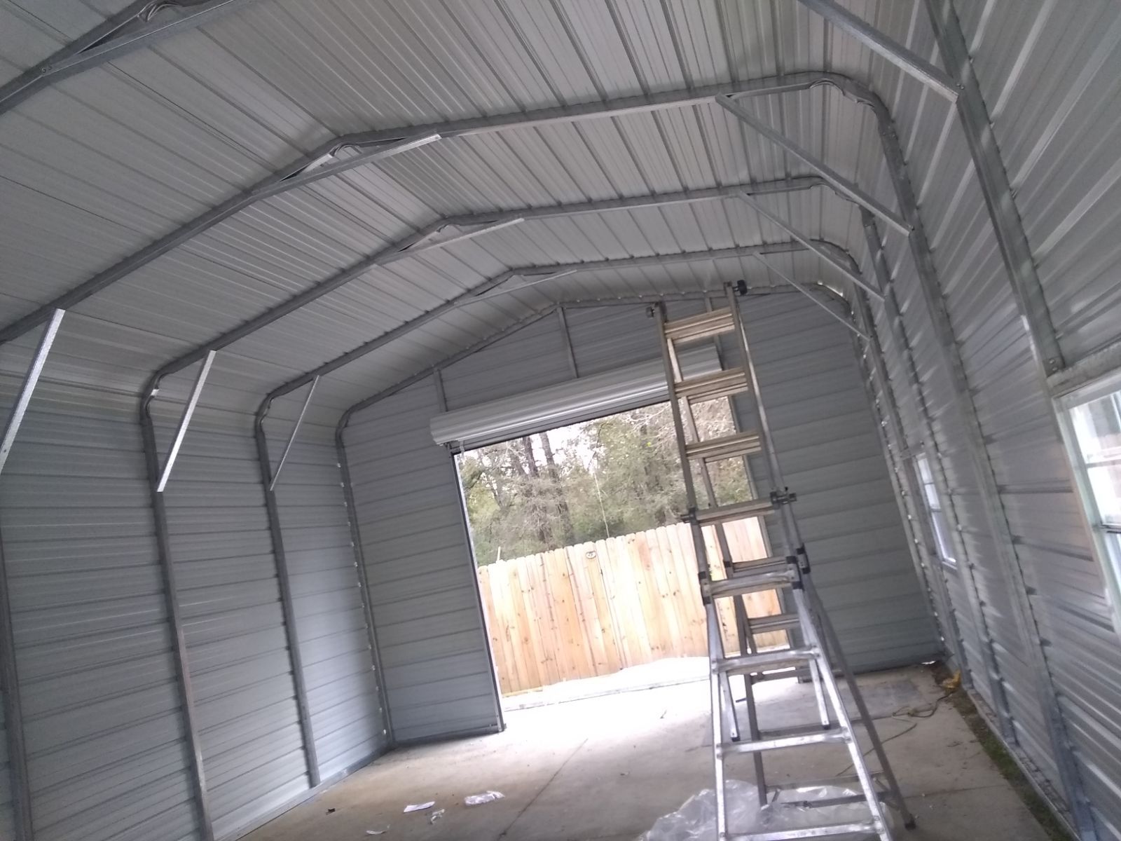 A metal garage with a ladder inside of it.