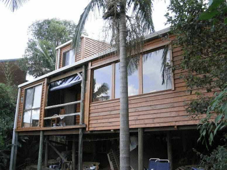 A Wooden House With A Palm Tree In Front Of It — Yves De Wilde Quality Painting Services In Lismore, NSW
