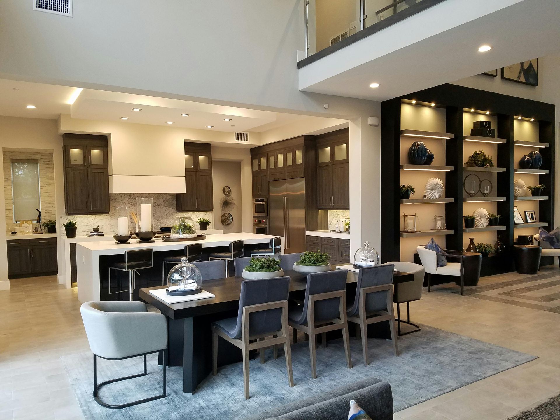 Open-concept kitchen and dining area with dark wood cabinets, a large table, and a built-in display shelf.