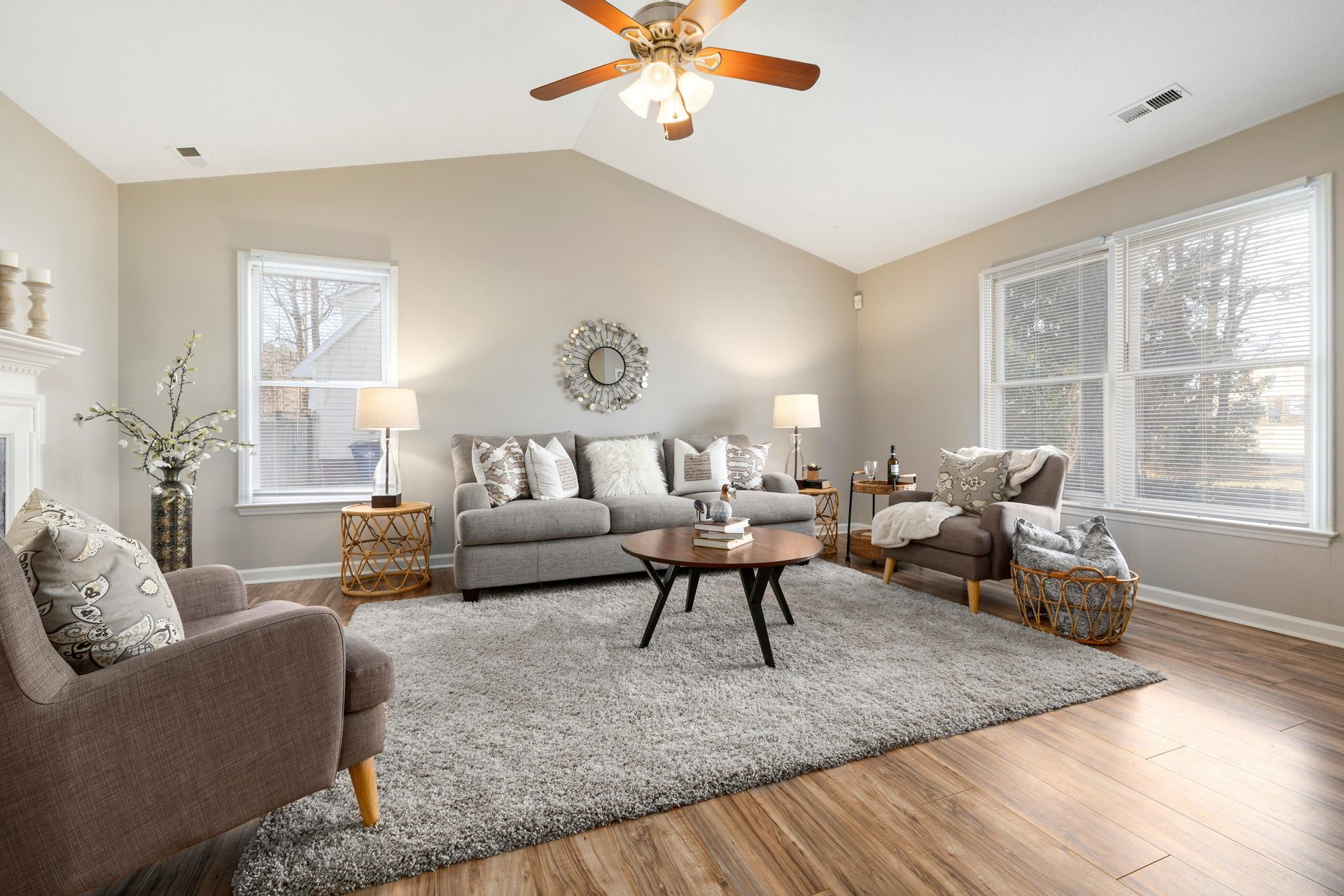 Living room with gray sofa, armchairs, rug, and coffee table.