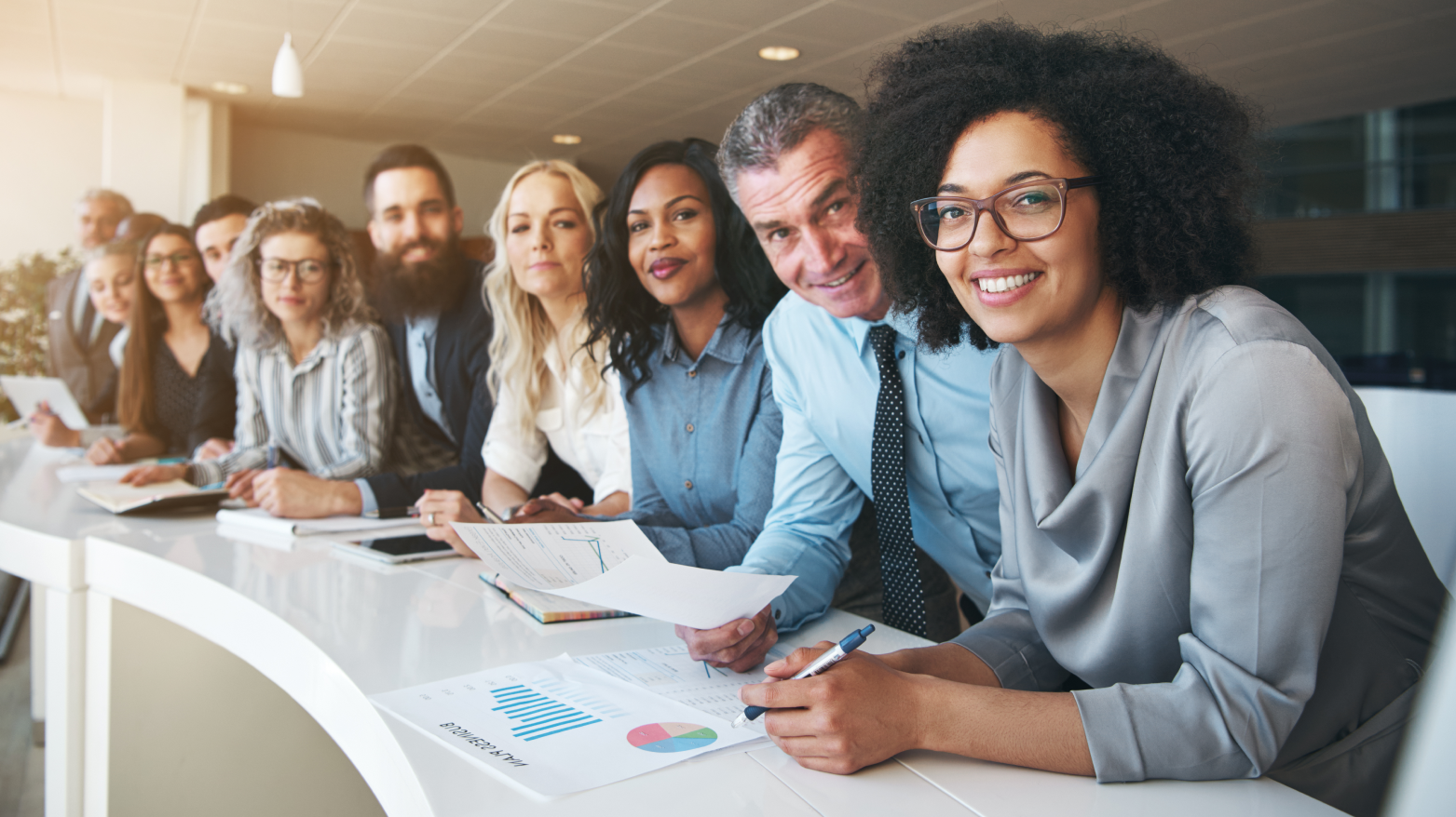 A group of business people are sitting at a table in a conference room.