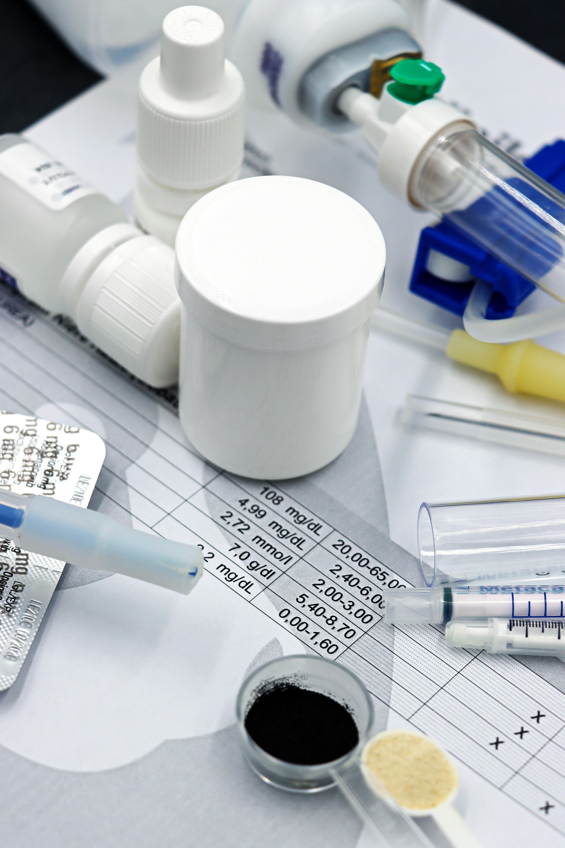 Medical supplies and prescription bottles on a clipboard with a test tube and syringe