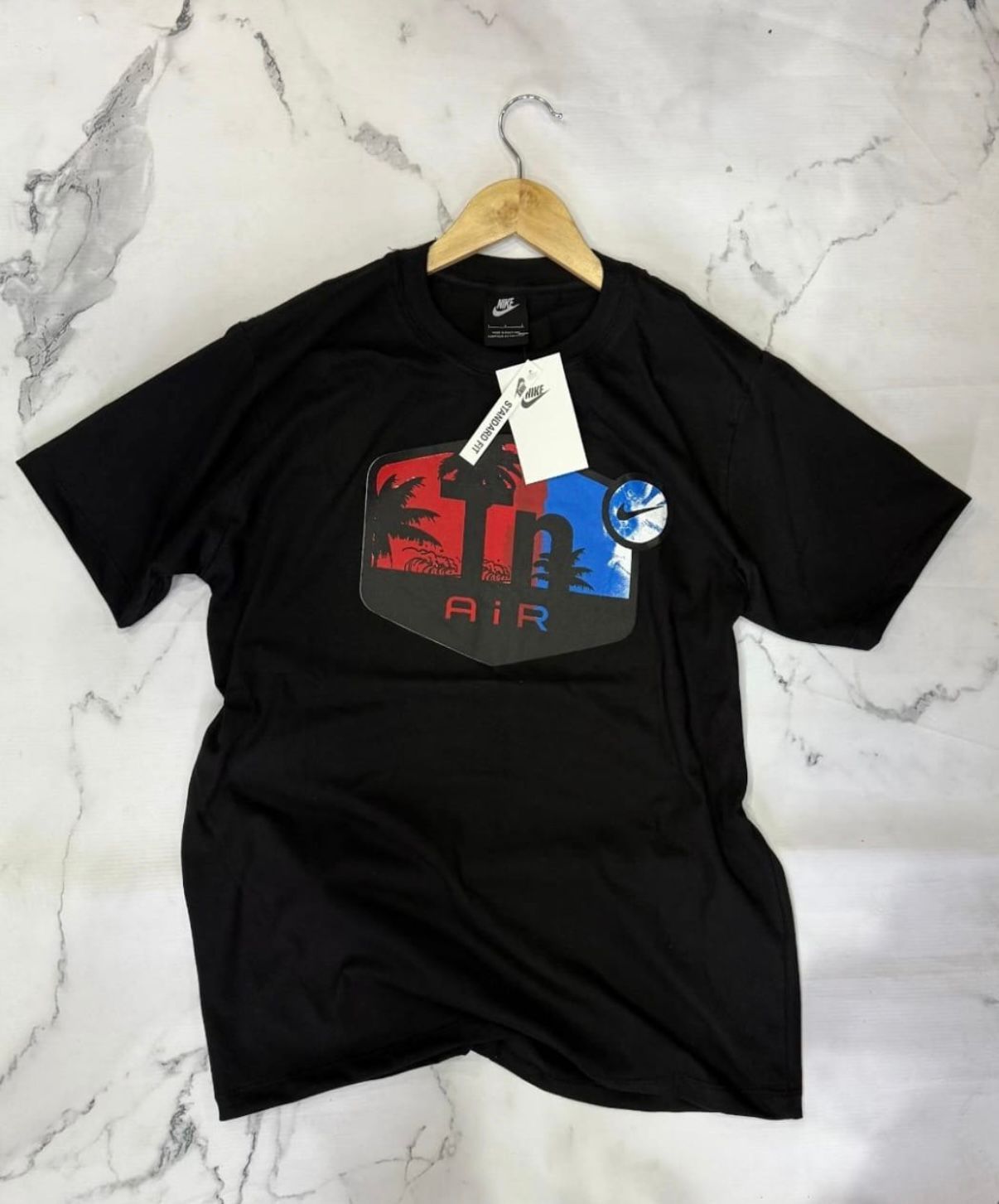 Camiseta Nike negra con un diseño gráfico colorido con el texto 