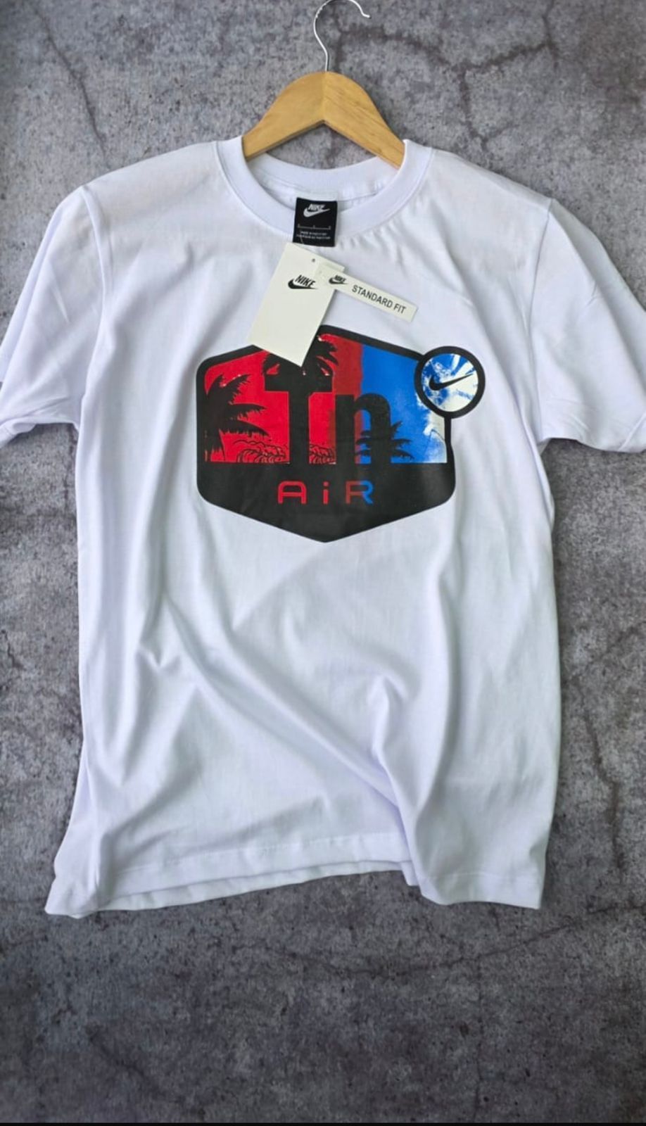 Camiseta Nike blanca con logotipo multicolor: gráfico rojo y azul, texto 