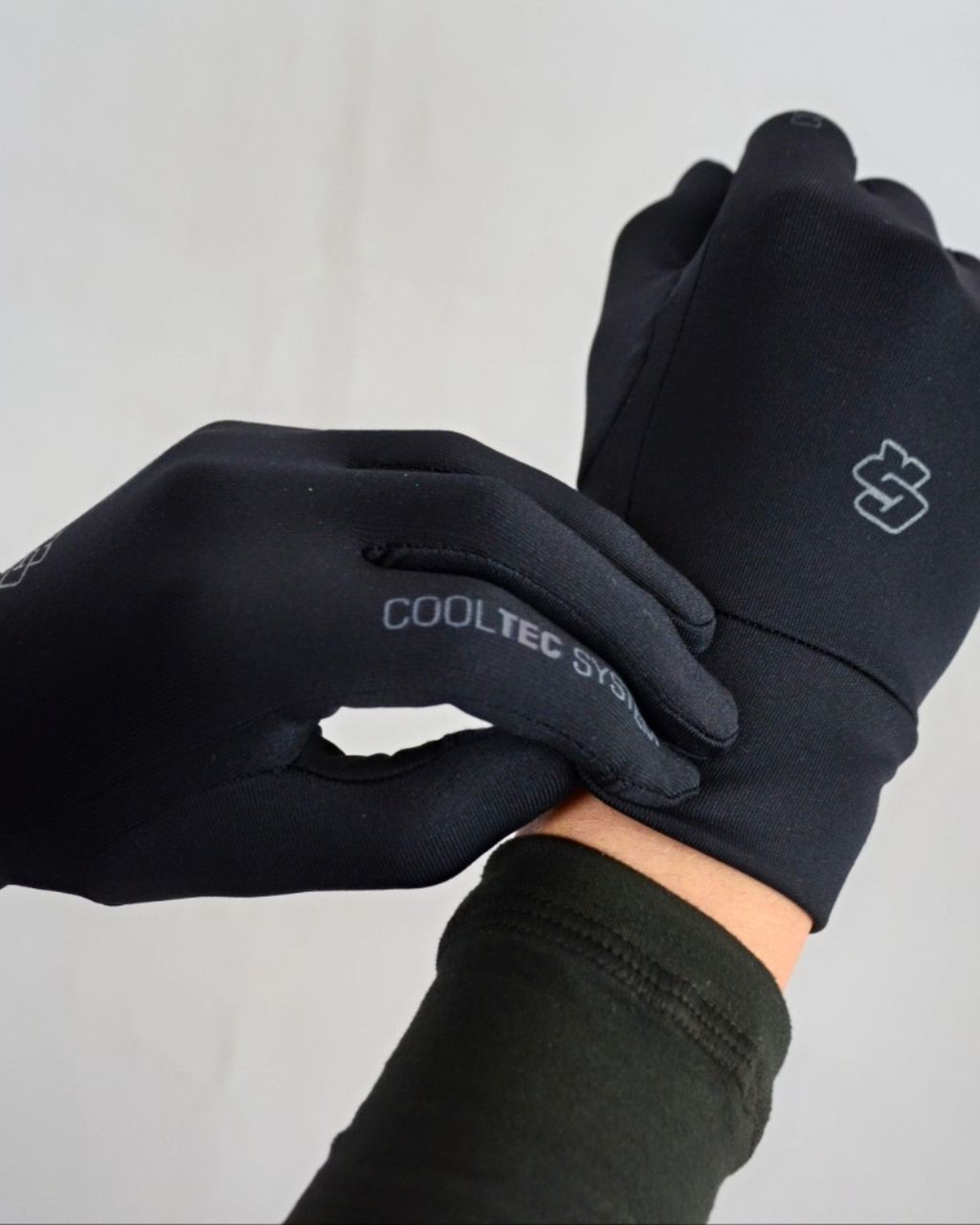 Una persona que lleva un par de guantes negros Cooltec