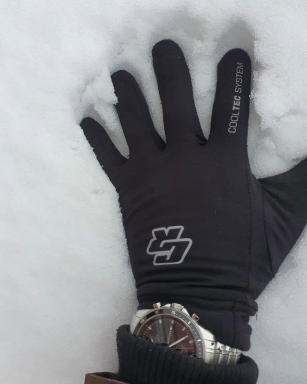 Una persona que lleva un par de guantes negros Cooltec