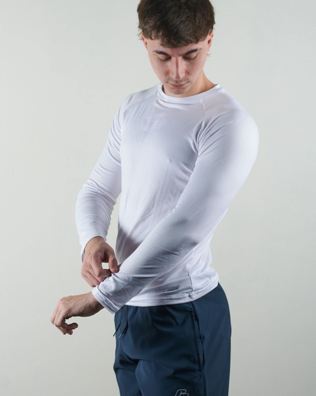 Un hombre que llevaba una camisa blanca de manga larga y pantalones cortos azules.