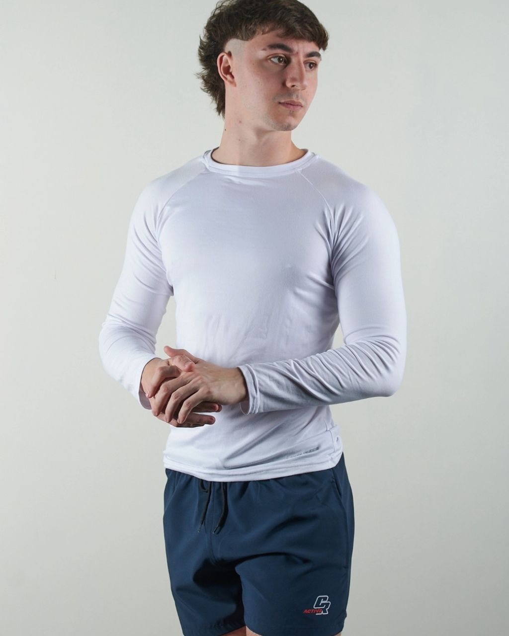Un hombre que llevaba una camisa blanca de manga larga y pantalones cortos azules.