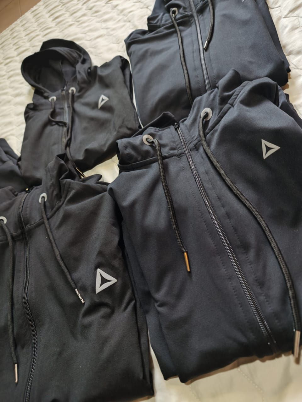 Cinco chaquetas negras con capucha y cremallera