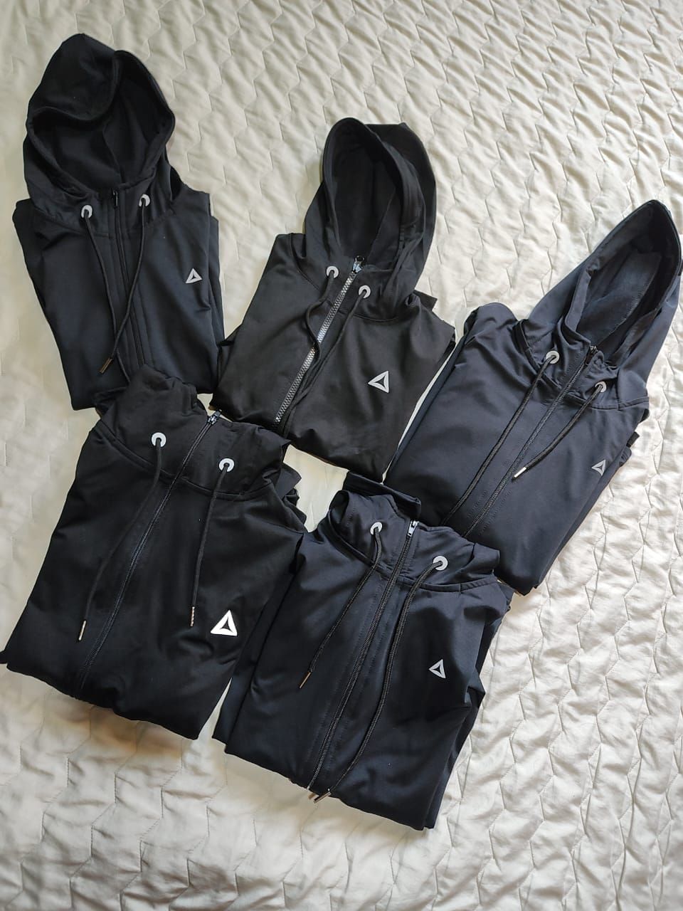 Cinco chaquetas negras con capucha y cremallera