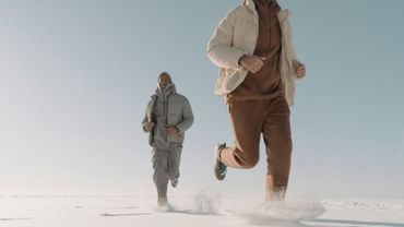 Un hombre y una mujer corren en la nieve.