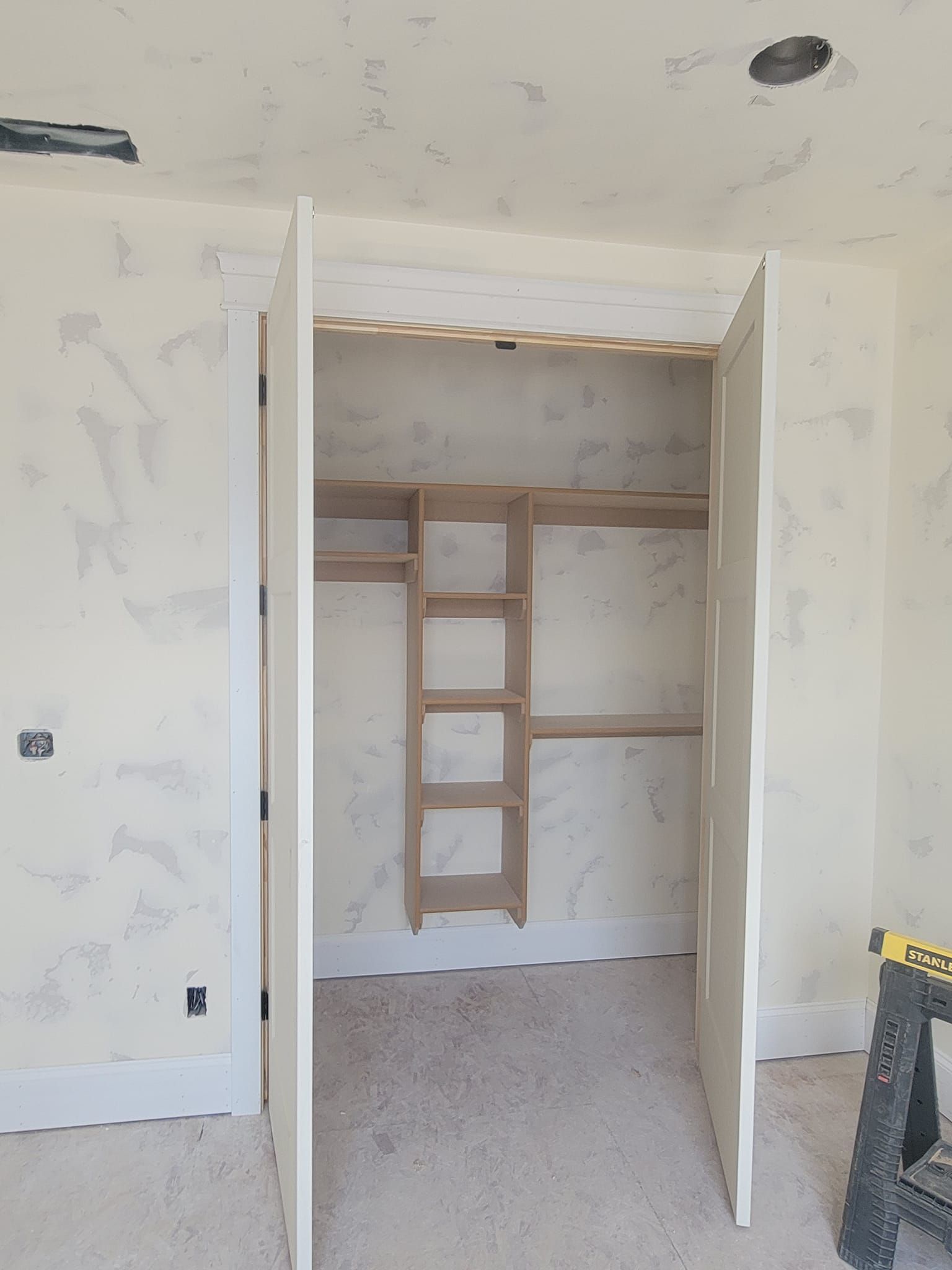 A closet with shelves and a ladder in it