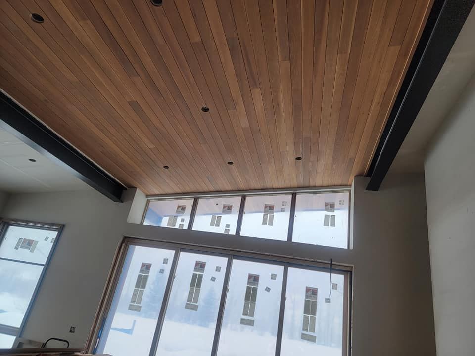 A room with a wooden ceiling and lots of windows