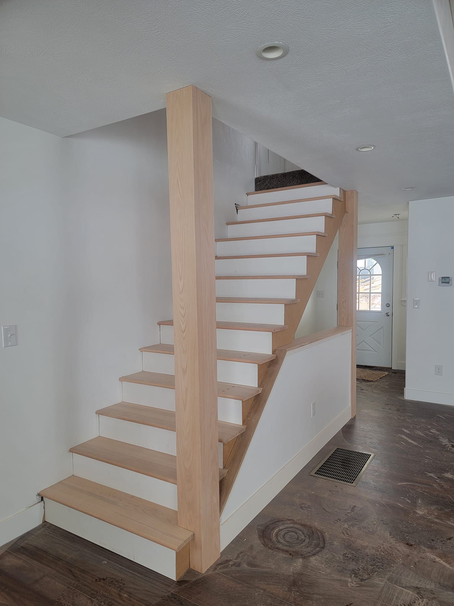 A wooden staircase is being built in a house.