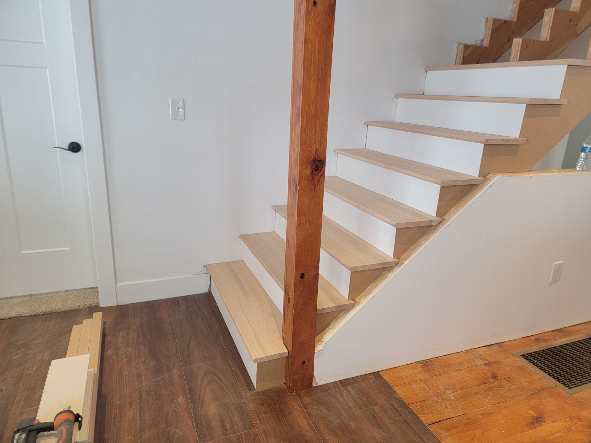 A wooden staircase is being built in a house.