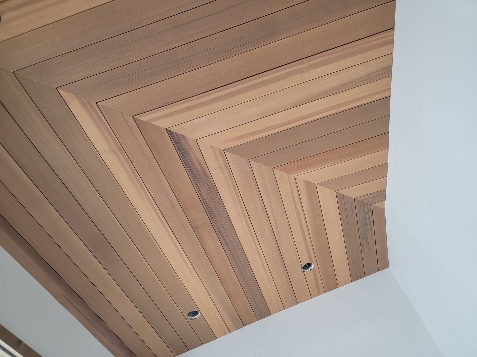 A wooden ceiling with a white wall in the background