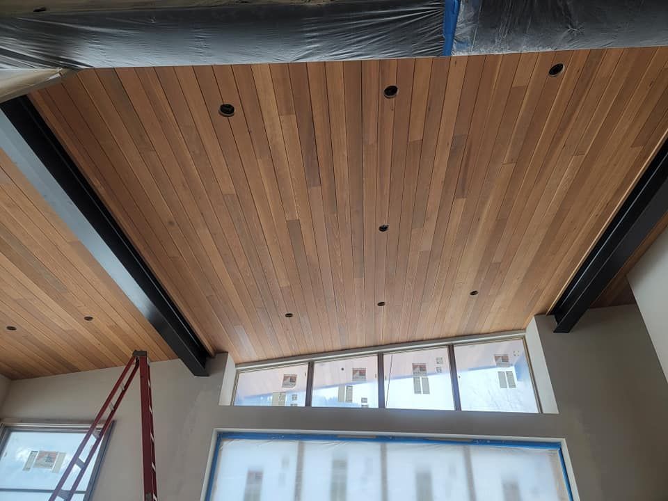 A room with a wooden ceiling and a window