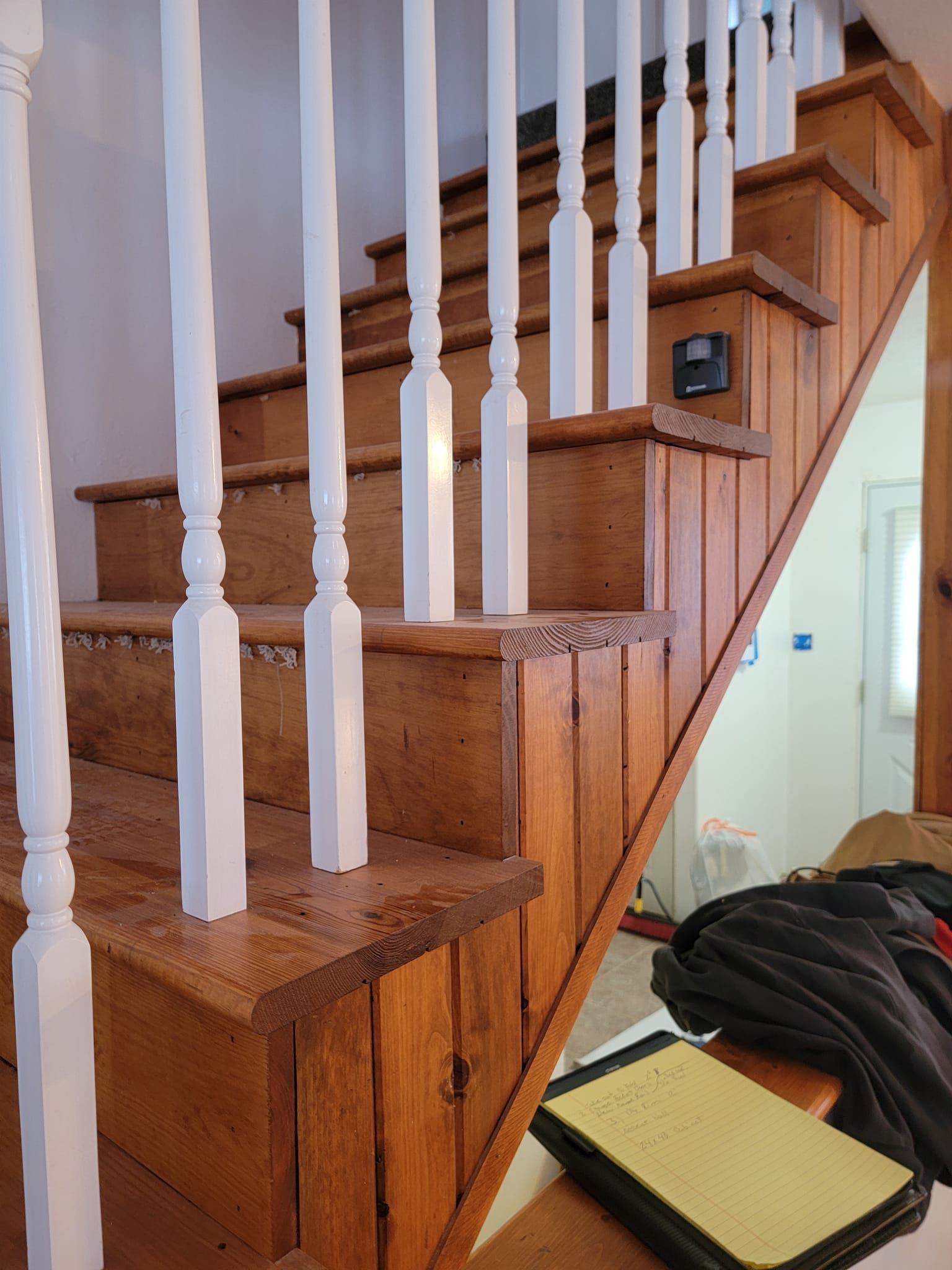 A set of wooden stairs with white railings