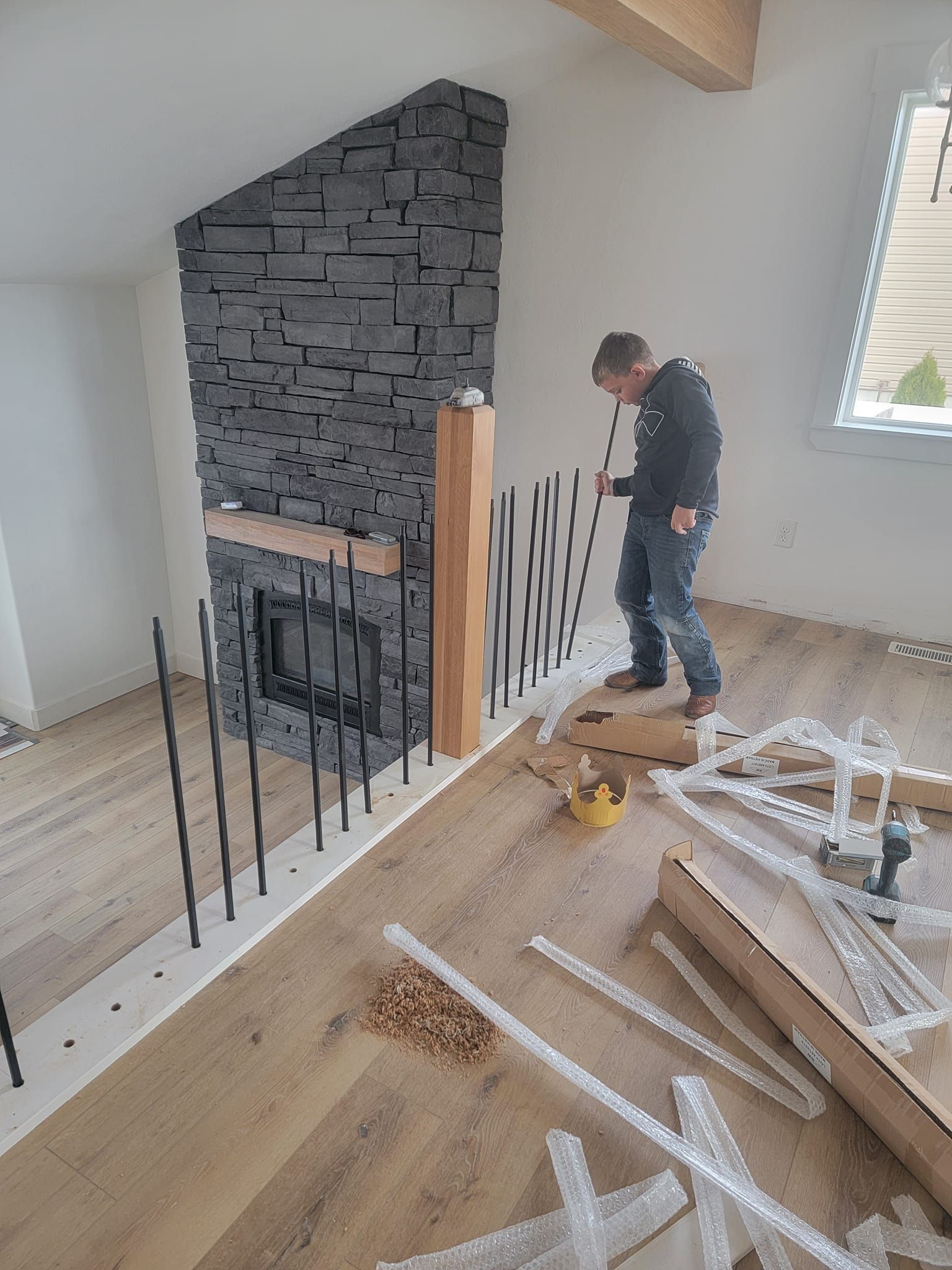 A man is working on a fireplace in a living room.