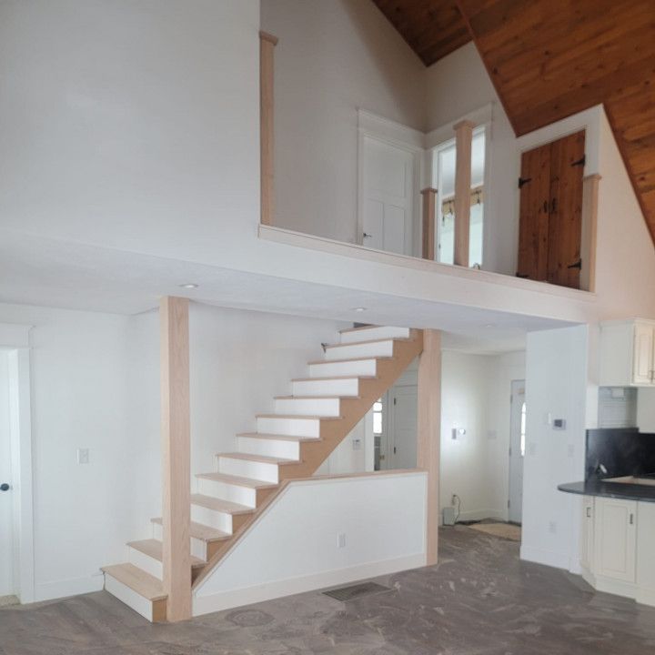 An empty room with a staircase leading up to the second floor