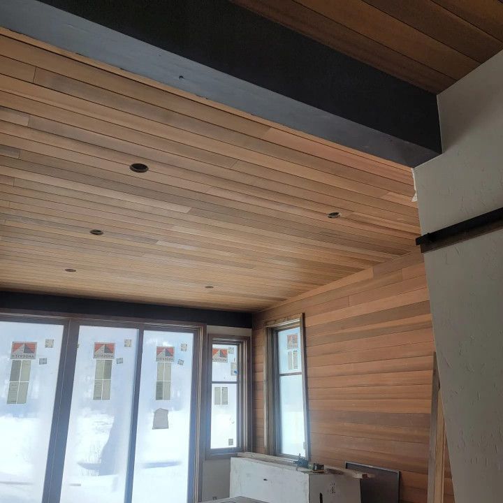 A room with a wooden ceiling and lots of windows