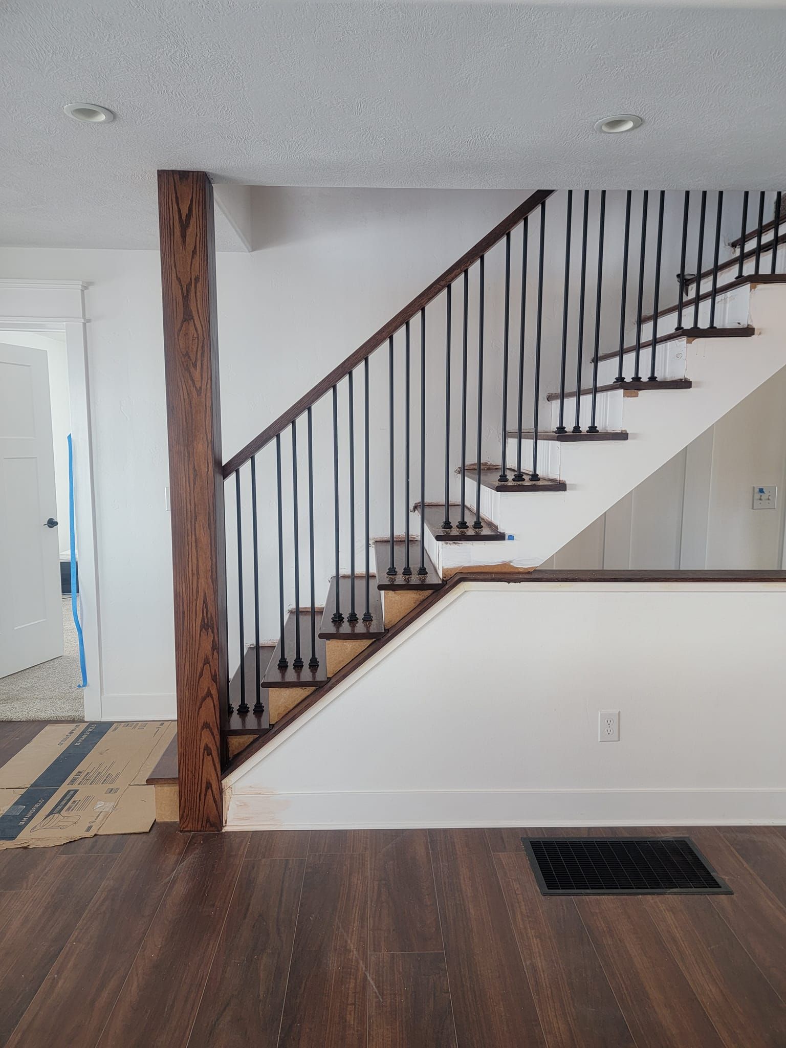 There is a staircase in the middle of the room with a wooden railing.