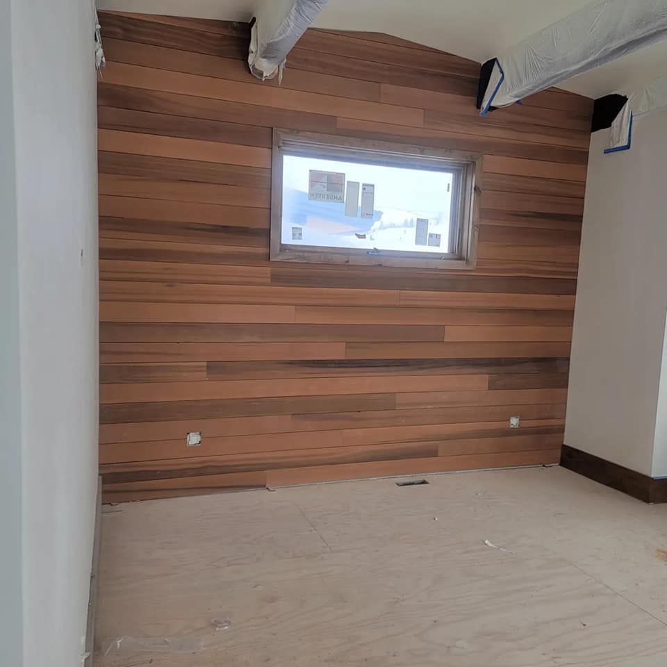 An empty room with a wooden wall and a window.