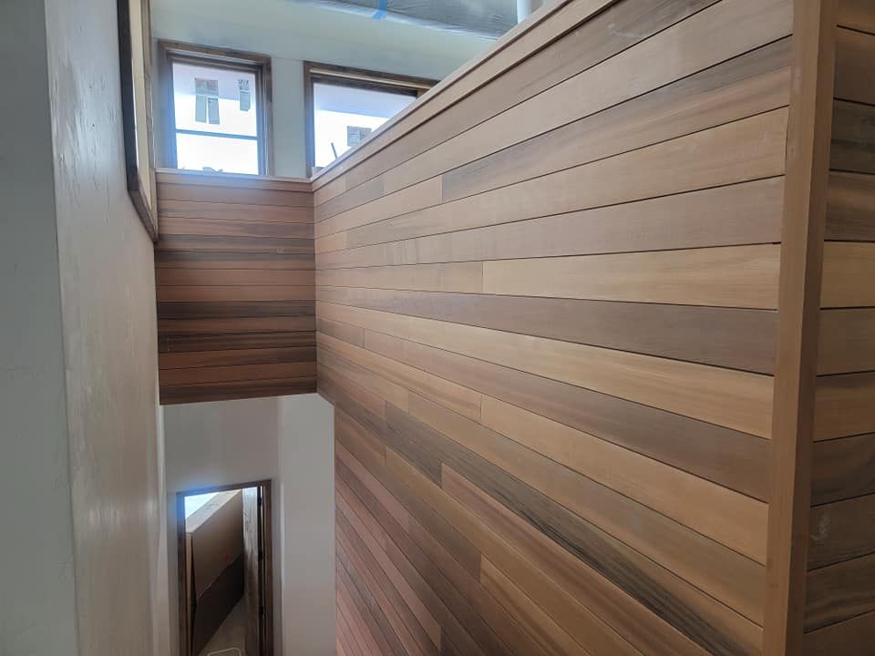 A wooden wall with a staircase in the background